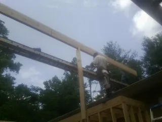 Carpenter setting a ridge beam over a new addition frame — Ice Dam Removal by Roofing Brothers in Allentown